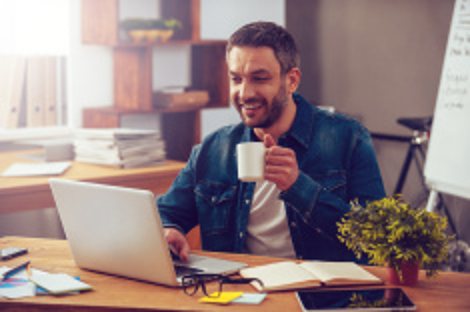 Man smiling at a laptop